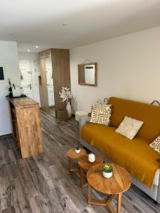 a living room with a couch and tables at Cozy studio with pool near the seaside in Roquebrune-sur-Argens