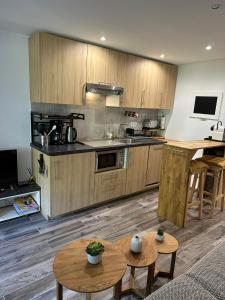 a kitchen with wooden cabinets and tables in a room at Cozy studio with pool near the seaside in Roquebrune-sur-Argens