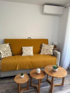 a living room with a couch and two tables at Cozy studio with pool near the seaside in Roquebrune-sur-Argens