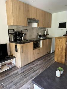 a large kitchen with wooden cabinets and a table at Cozy studio with pool near the seaside in Roquebrune-sur-Argens