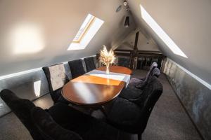 a dining room with a wooden table and chairs at Royal Wood Hotel in Rokytne
