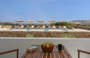 a table with a bowl of fruit on top of a house at Agnadi Hotel in Agia Anna Naxos