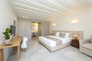 a bedroom with a large white bed and a couch at Agnadi Hotel in Agia Anna Naxos