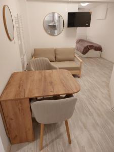 a living room with a wooden table and a couch at Juraj apartman studio in Brdovec +28 photos