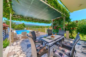 a patio with a table and chairs and a pool at Villa with pool near Split in Krušvar