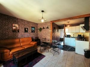 a living room with a couch and a table and a kitchen at La Chambres des Secrets in Vierzon +43 photos