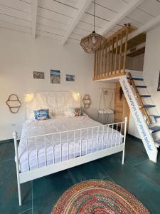 a bedroom with a white bed and a staircase at SUN Bungalow Costinești in Schitul +68 photos