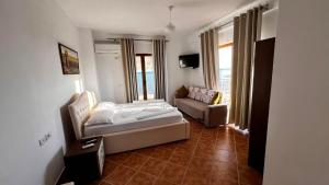a bedroom with a bed and a couch in a room at Erjani Hotel in Velipojë