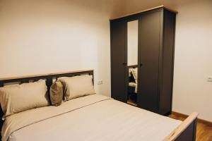 a bedroom with a bed and a black cabinet at Casa Monti in Ijevan
