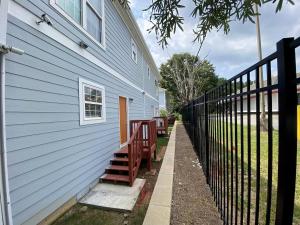 a blue house with a fence next to a porch at Basic 4 bedrooms with 6 beds 15 min from downtown sleeps 9 Adults comfortably for Work crews and Large groups in Atlanta +13 photos