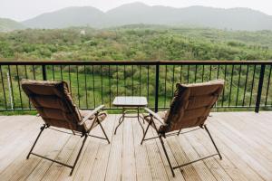 two chairs and a table on a deck with a view at Casa Monti in Ijevan