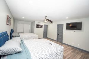 a bedroom with two beds and a flat screen tv at Spacious Dawsonville 4 bedrooms with 8 beds Sleeps 10 for Work crews and Large groups of friends and families in Dawsonville