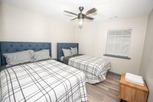 a bedroom with two beds and a ceiling fan at Spacious Dawsonville 4 bedrooms with 8 beds Sleeps 10 for Work crews and Large groups of friends and families in Dawsonville +24 photos