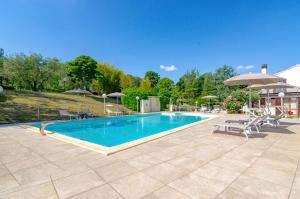 a swimming pool with patio furniture and umbrellas at Villa Ca' Viola Rimini in Rimini