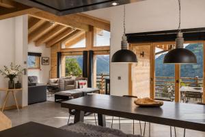 a dining room with a table and a living room at Chalet Aramis in Riddes