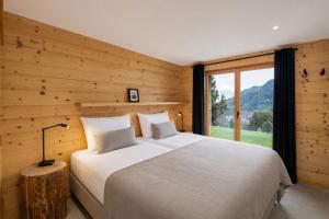 a bedroom with a bed and a large window at Chalet Aramis in Riddes