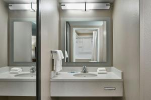 a bathroom with two sinks and a mirror at SpringHill Suites by Marriott Atlanta Alpharetta in Alpharetta +26 photos