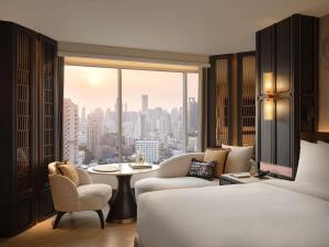 a bedroom with a bed and a view of a city at Fairmont Bangkok Sukhumvit in Bangkok