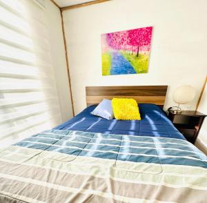 a bedroom with a blue bed with a yellow pillow at Cabañas buchupureo in Buchupureo
