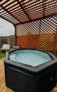 a hot tub on a deck with a pergola at Cabañas buchupureo in Buchupureo