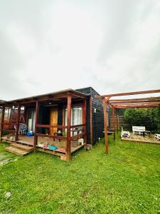 a small house in a yard with a grass field at Cabañas buchupureo in Buchupureo