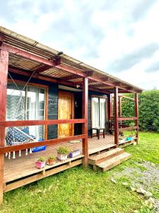 a house with a deck with a swing at Cabañas buchupureo in Buchupureo