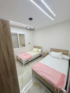 a bedroom with two beds and a window at Coronado Marina in Ain Sokhna