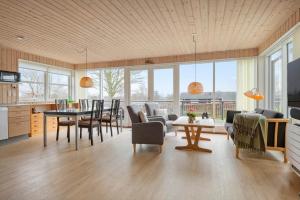a kitchen and living room with a table and chairs at 30472-Odder-Ravnsager-20 in Dyngby +23 photos