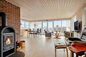 a living room with a fireplace and a brick wall at 30472-Odder-Ravnsager-20 in Dyngby