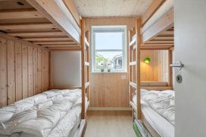 a group of bunk beds in a room with a window at 30472-Odder-Ravnsager-20 in Dyngby