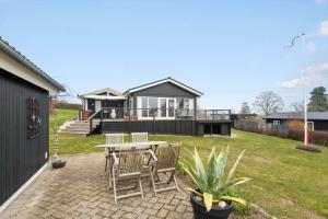 a patio with a table and chairs and a house at 30472-Odder-Ravnsager-20 in Dyngby