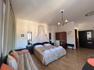 a bedroom with a large bed and a couch at Archontiko Tsikari in Város