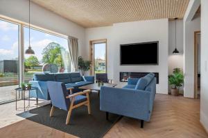 a living room with blue couches and a tv at 30433-Saksild-Strand-Odder-Strandlodden-2 in Rude