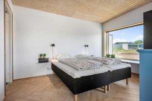 a bedroom with a large bed and a large window at 30433-Saksild-Strand-Odder-Strandlodden-2 in Rude