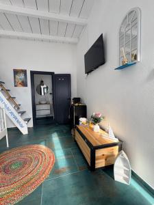 a living room with a table and a tv on a wall at SUN Bungalow Costinești in Schitul