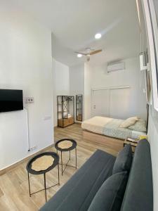 a room with a bed and two chairs and a couch at Grampy Boutique Hostal - Zaragoza Centro in Zaragoza