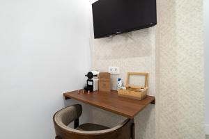 a room with a table and a chair and a television at Rosales Suites in Madrid