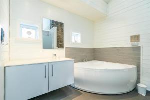 a white bathroom with a tub and a sink at 173-Ringkobing-Sondervig-Landevej-29 in Søndervig +29 photos