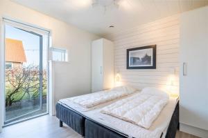 a bed in a room with a large window at 173-Ringkobing-Sondervig-Landevej-29 in Søndervig