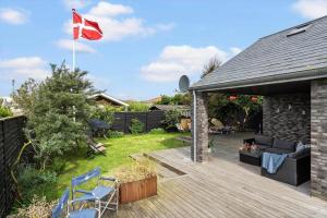 a house with a flag on a wooden deck at 173-Ringkobing-Sondervig-Landevej-29 in Søndervig