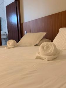 a bed with two towels sitting on top of it at Hotel Bom Gosto in Taiobeiras