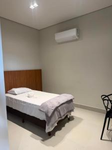 a white room with a bed and a fan at Hotel Bom Gosto in Taiobeiras