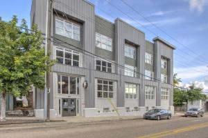a large gray building with cars parked in front of it at The Stallion #305 - Walk to Attractions - Modern Spacious 1BD Loft in Memphis Downtown in Memphis