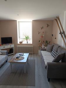 a living room with a couch and a table at Monts et Rêves in Ramonchamp
