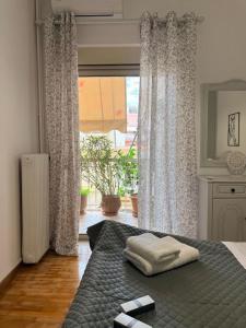 a bedroom with a bed and a large window at KATERINA's House in Preveza