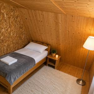 a bedroom with a bed in a wooden cabin at Country house in nature -10 min from Nikola Tesla Memorial Center-peace and privacy in Klanac
