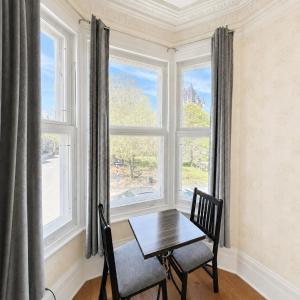 a dining room with a table and two chairs and a window at Manoir Sainte Genevieve in Quebec City