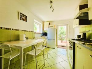 a kitchen with a table and chairs and a refrigerator at Rozbrykany Muflon in Witoszów Dolny