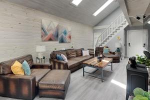 a living room with leather furniture and a staircase at In The Middle in Oakland