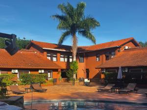 a resort with a palm tree and a swimming pool at Marcopolo Suites Iguazu in Puerto Iguazú